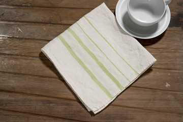White Dinner Napkin with Green Bands Design Alongside Empty Teac