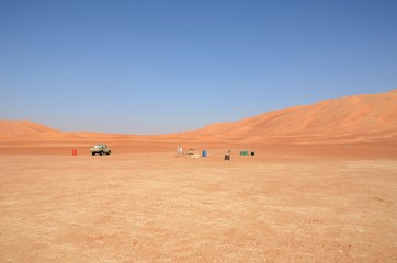 Lonely car on desert plane with sand dunes
