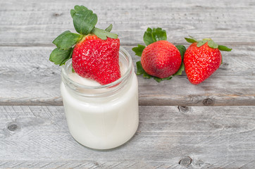 Homemade natural yogurt with strawberries fruits on a wooden tab