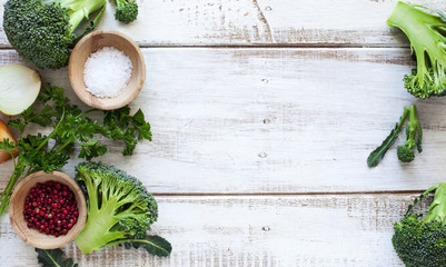 Obraz na płótnie Canvas Fresh green broccoli, parsley, onion, salt and red pepper on woo