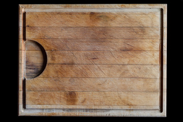 Rough wooden rectangular used cutting board background with horizontal lines and cutting traces directly from above on black background