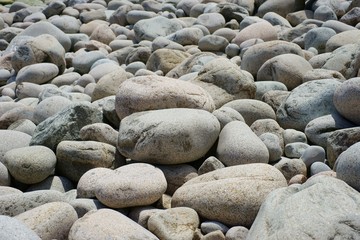 Grey sea pebbles in variety of sizes close up.