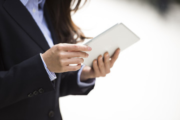 Woman wearing a business suit is looking at the information in the tablet