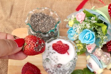 Chia seeds with milk and fresh strawberries.