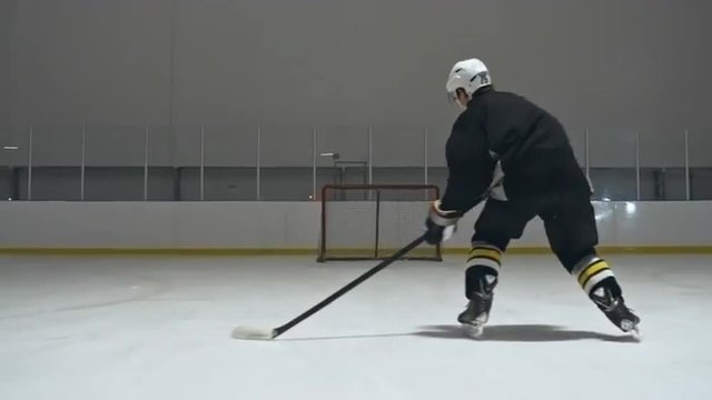 Follow shot of hockey player skating and scoring a goal
