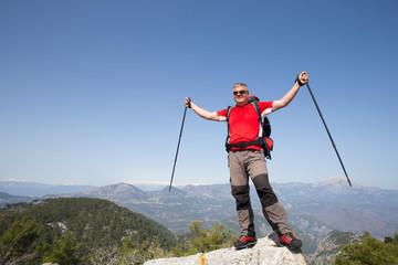  Hiker standing on top of the mountain with valley on the background.