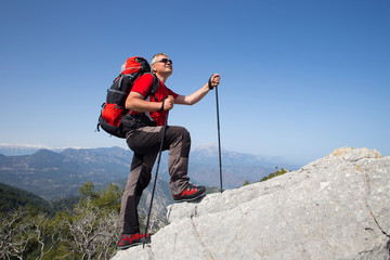  Hiker standing on top of the mountain with valley on the background.