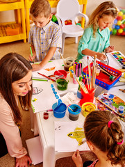 Children with teacher woman learn painting on color paper in  art class kindergarten . Top view. - 104887173