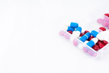 Red, blue and white pills in box on a white background