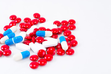 Red, blue and white pills on a white background