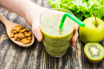 Healthy green smoothie with kiwi and apples on  wooden background
