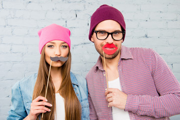 Two funny lovers holding props and preparing for party - obrazy, fototapety, plakaty
