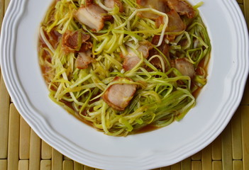 stir-fried white garlic chives with crispy pork on dish