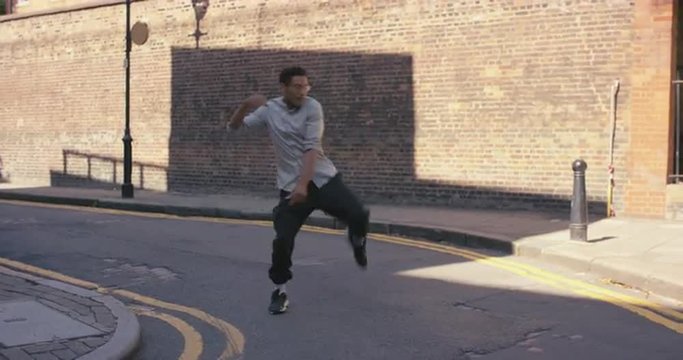 Contemporary funky mixed race man street dancer dancing freestyle in the city