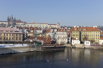 The snowy Prague's gothic Castle above the River Vltava
