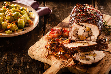 Stuffed pork sliced with bacon on cutting board