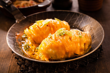 Baked sliced potatoes topped with cheese