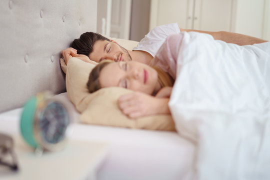 ehepaar liegt morgens im bett und schläft