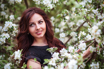 portrait of a spring woman, face female enjoying cherry blossom