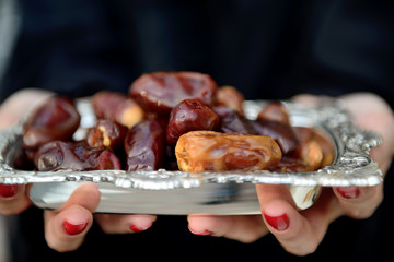 Emarati Arab woman holding dates plate
