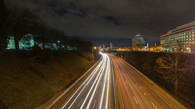 Ultra high definition 4k time lapse movie of clouds and long exposure freeway traffic light trails on interstate 84 highway leading into downtown city of Portland Oregon at night 4096x2304