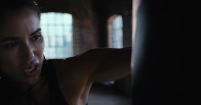 Kickboxing woman training punching bag in fitness studio