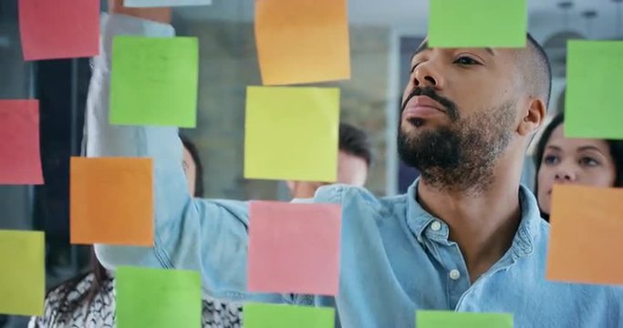 Creative business team brainstorming ideas working together sharing data late at night after hours in modern glass office