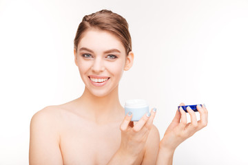 Smiling cute woman holding facial cream