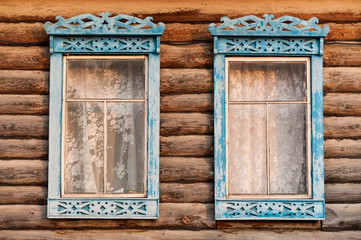 Fototapeta na wymiar Wall of blockhouse with toreutic windows