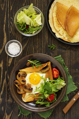 Pancakes with fried egg and fried mushrooms.