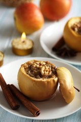 Baked apples on plate on blue wooden table