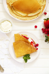 Pancakes filled with whipped cream and berries.