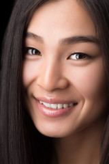 Close-up of smiling Asian woman in studio