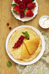 Russian pancakes with honey and fresh berries.