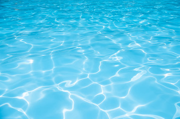 Naklejka na ściany i meble Blue water in swiiming pool with sun reflection