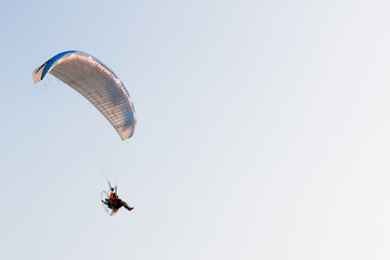 A man ride Paraglider or Paramotor flying in the sky