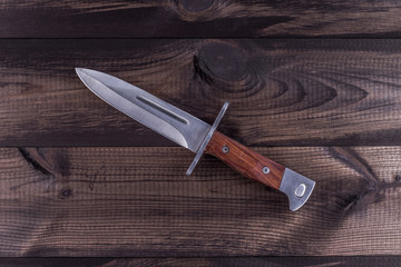 Combat  knife  on wooden background. Bayonet for Kalashnikov rifle.