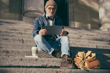 Older man using his phone on the street