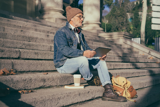 Older man using his phone on the street