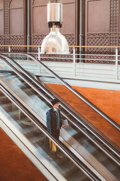 Elderly man down the escalator