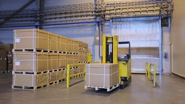 Man on forklift transporting cargo from one storage to another
