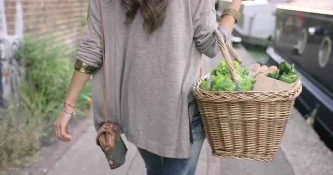 Beautiful woman shopping basket healthy fresh vegetables walking in city