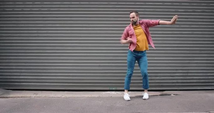 Contemporary funky caucasian man street dancer dancing freestyle in the city