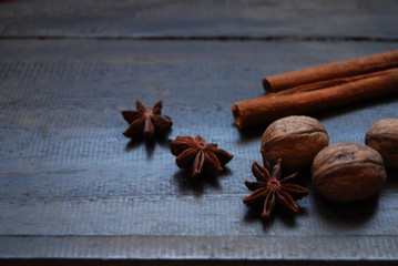 Star anise, cinnamon sticks and walnuts on dark wooden backgrounds, close-up