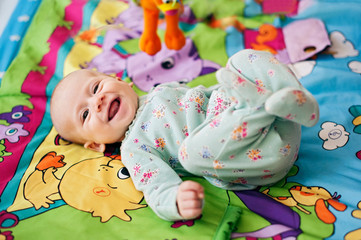 Happy little baby smiling laying in bed