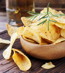 Chips in a wooden bowl and beer