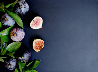 Obraz na płótnie Canvas figs with leaves on a black, selective focus