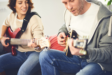 Musician teaching his girlfriend playing electric guitar