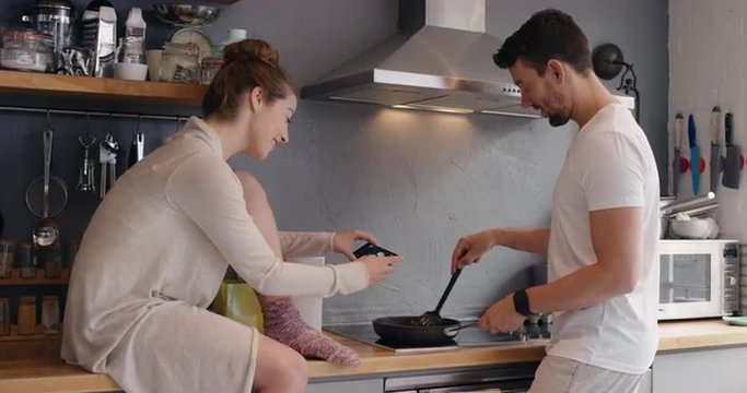 Happy couple Taking photo using smart phone of breakfast frying egg for social media lifestyle at home in kitchen