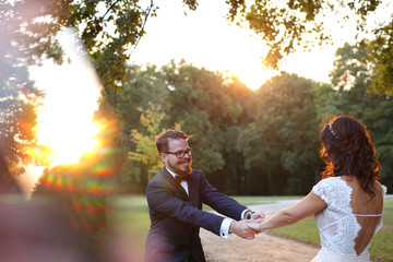 Joyful bridal couple embracing in the park